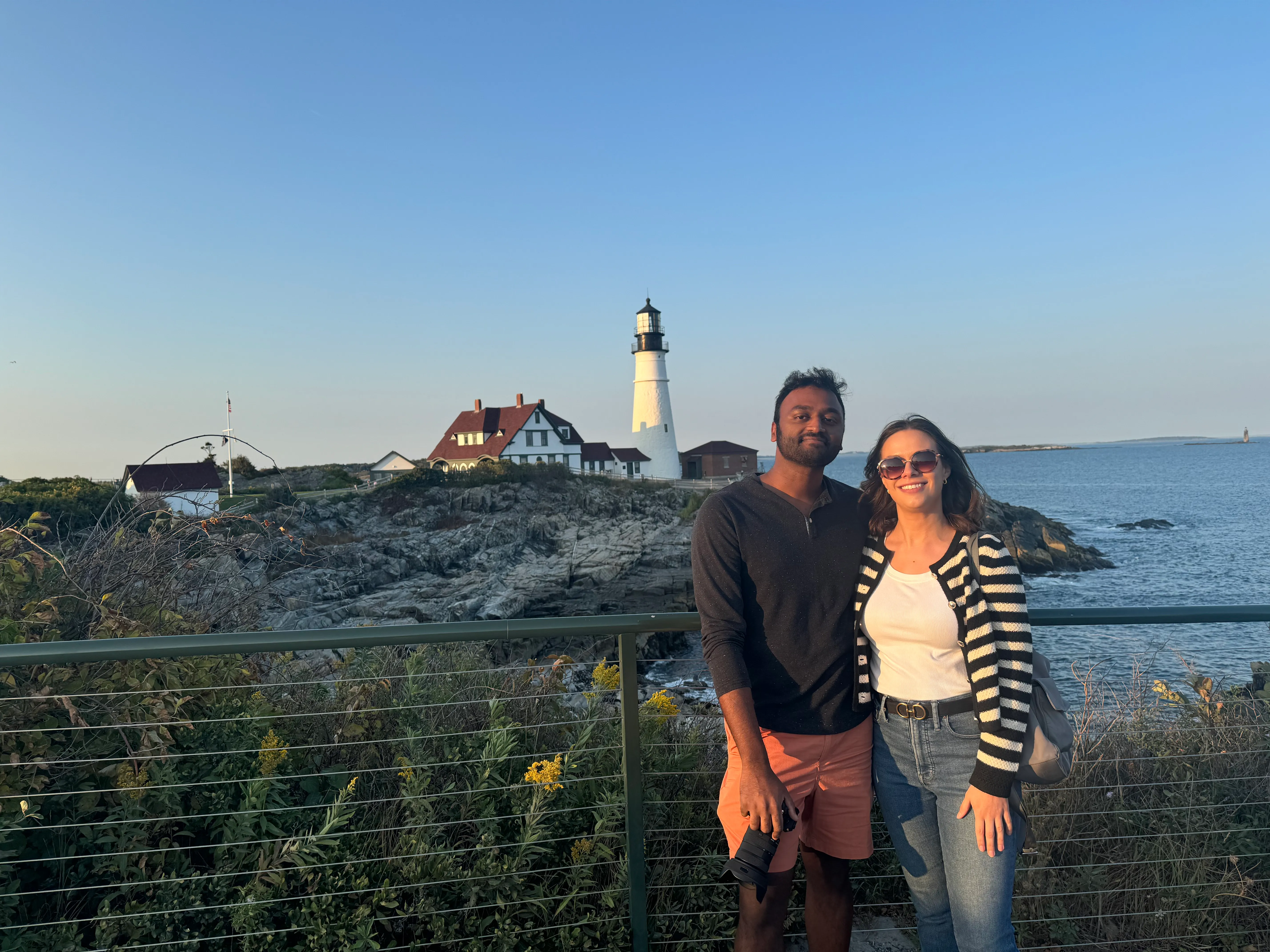Brianna and Ivan near a lighthouse on the coast.