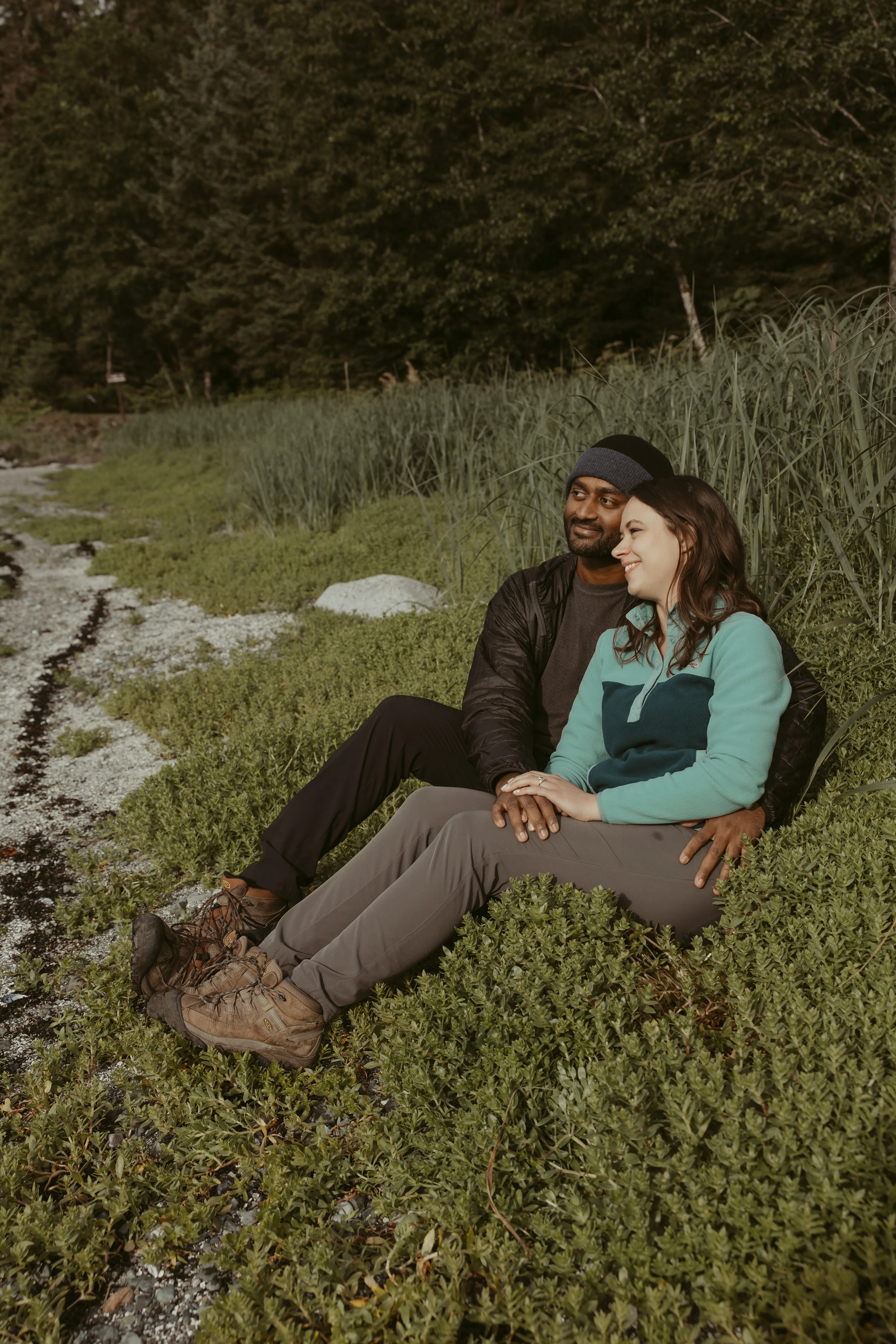 Brianna and Ivan seated together by the shoreline.