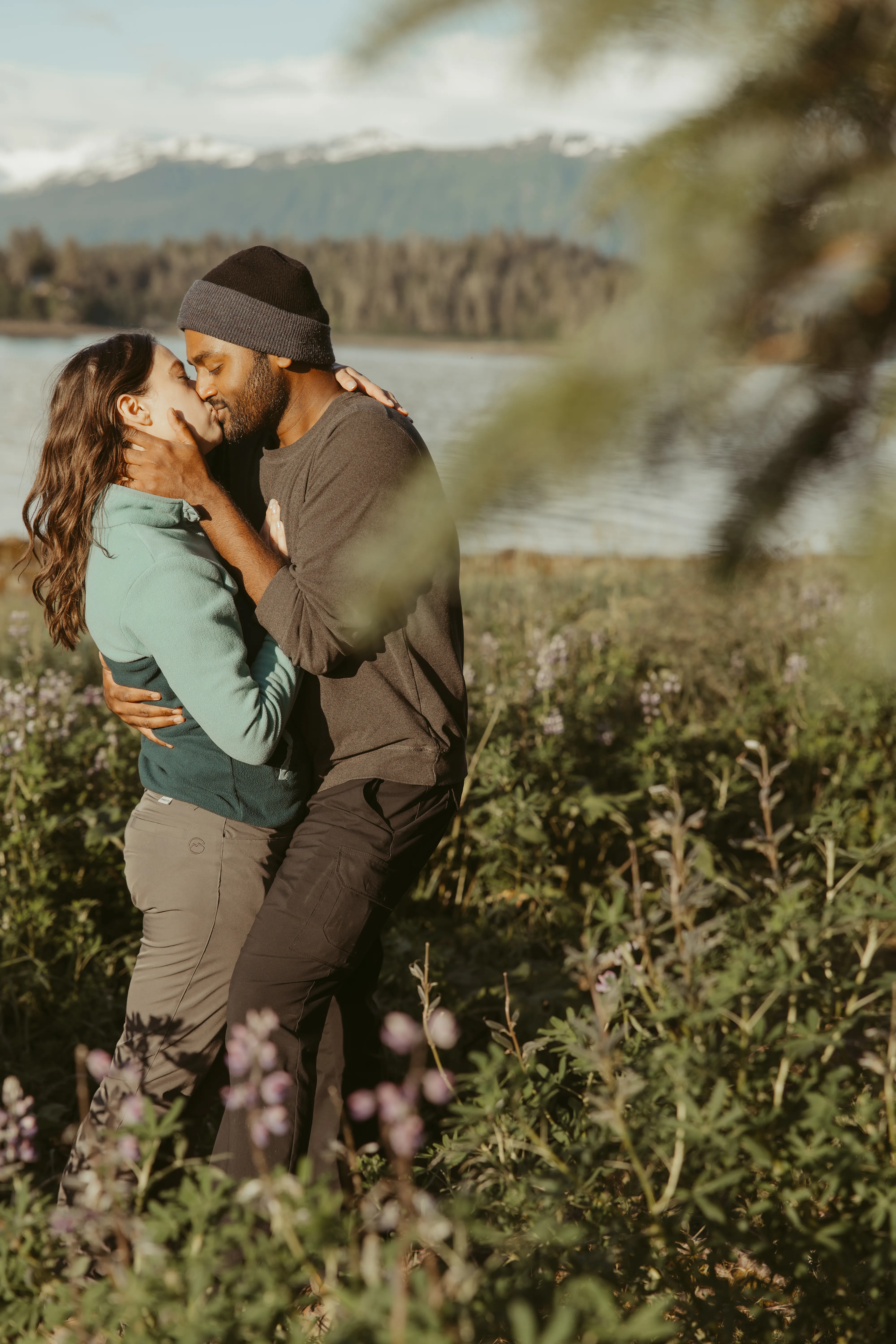 Brianna and Ivan sharing a kiss beside the water.