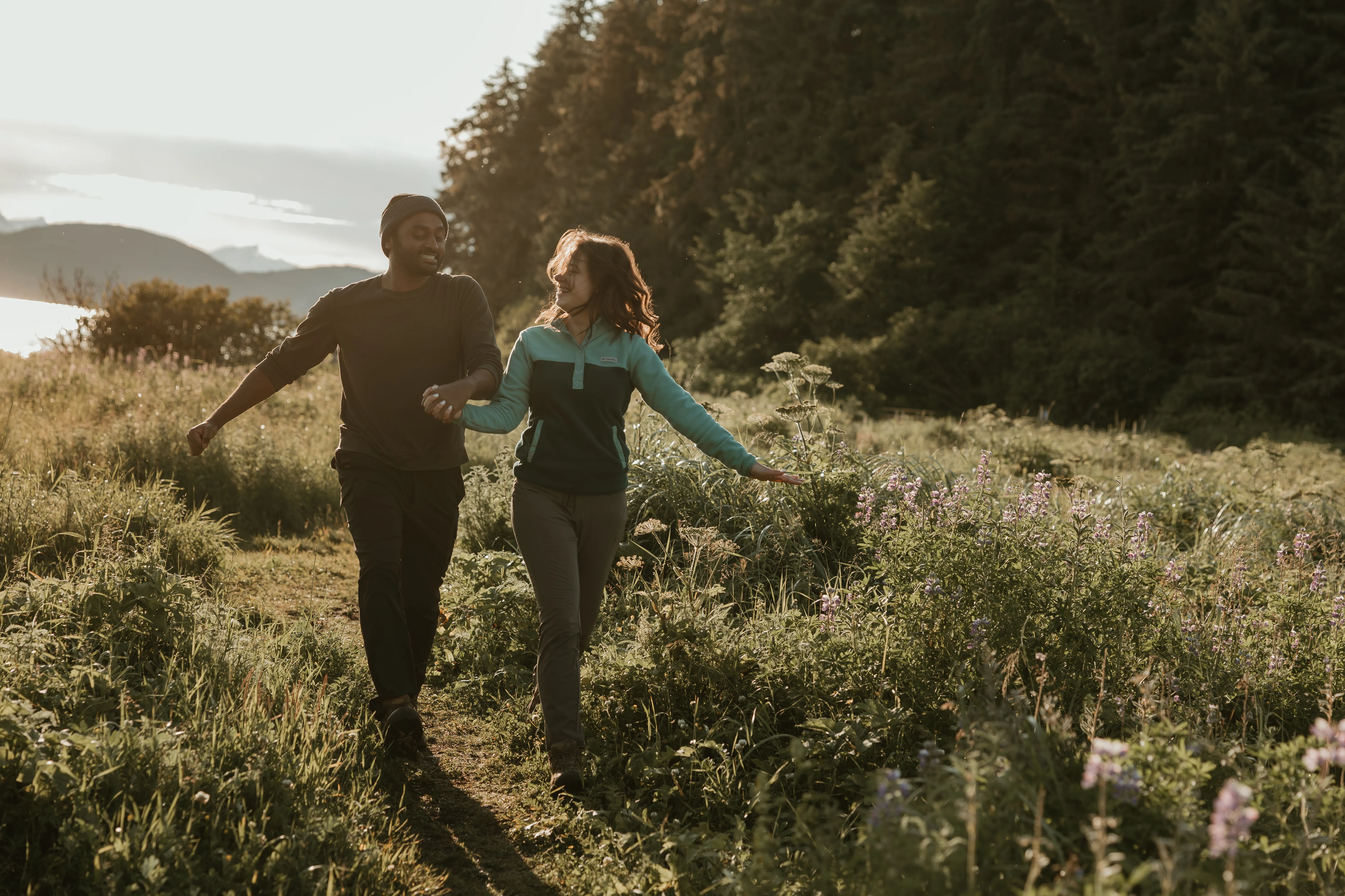 Brianna and Ivan walking through a sunny meadow.