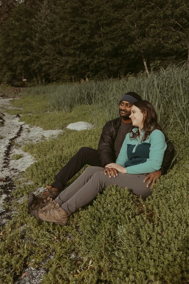 Brianna and Ivan seated together by the shoreline.